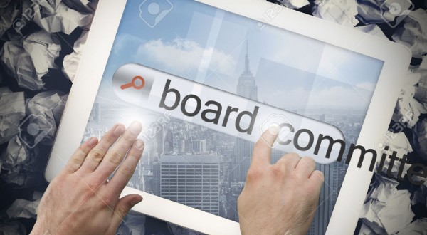 26807254-hand-touching-the-word-board-committees-on-search-bar-on-tablet-screen-on-crumpled-papers